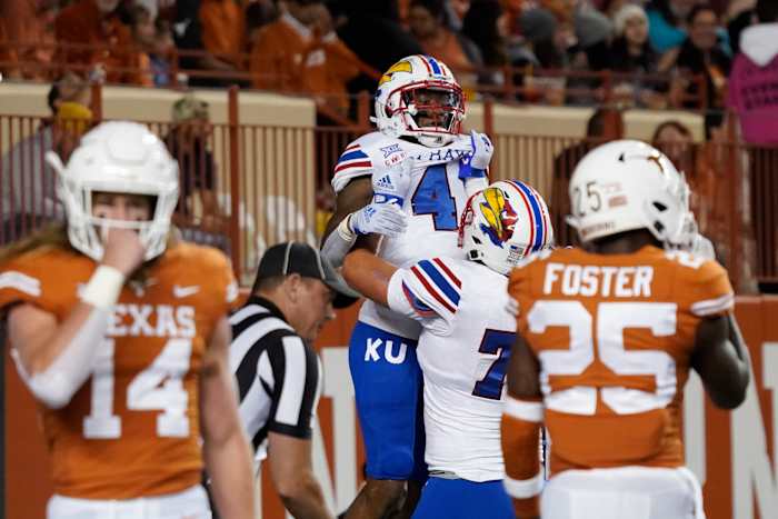 Nov 13, 2021; Austin, Texas, USA; Kansas Jayhawks running back Devin Neal (4) is lifted by offensive lineman Bryce Cabeldue after scoring a touchdown during the first half against the Texas Longhorns at Darrell K Royal-Texas Memorial Stadium. Mandatory Credit: Scott Wachter-USA TODAY Sports